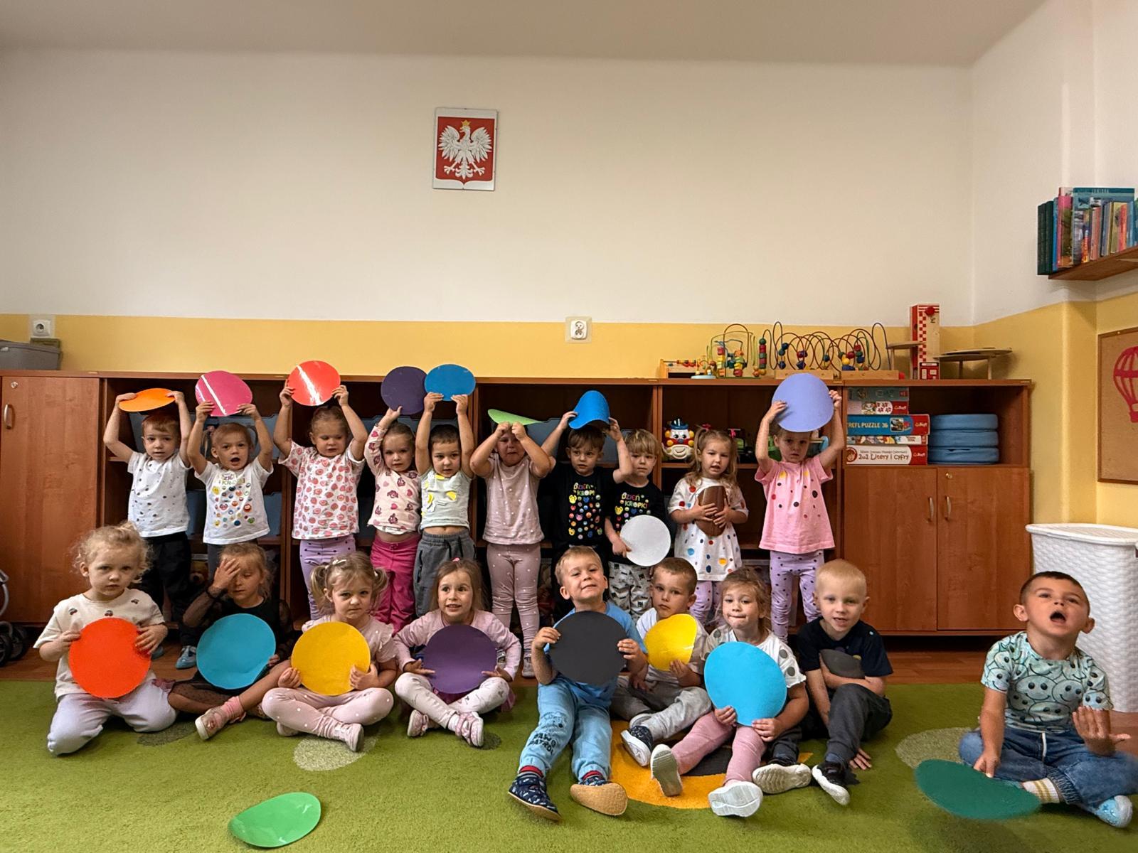 Grupowe zdjęcie dzieci z kolorowymi kółkami