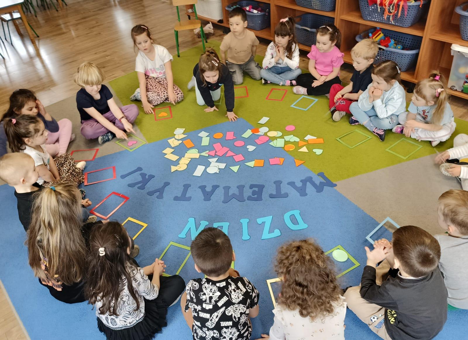 Dzieci na dywanie wykonują działania matematyczne